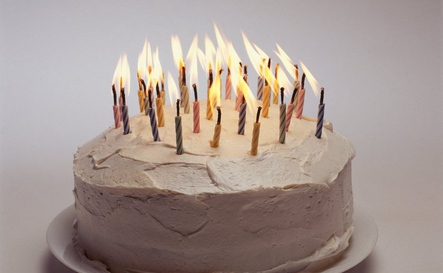 A picture of a birthday cake with lit candles.