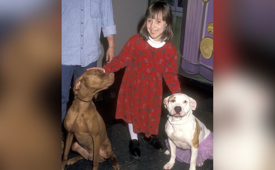 Mara Wilson poses for a photo with two dogs.
