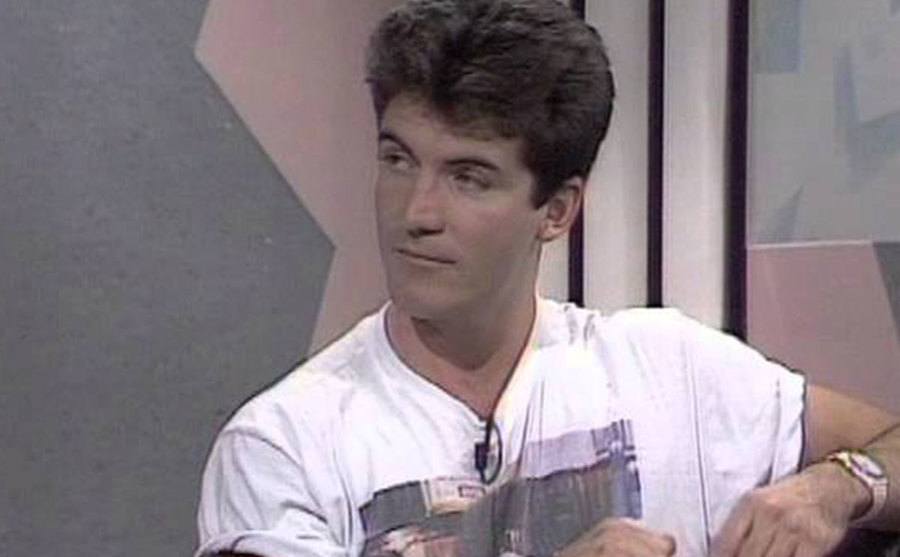 A video still of a younger Simon Cowell on television.