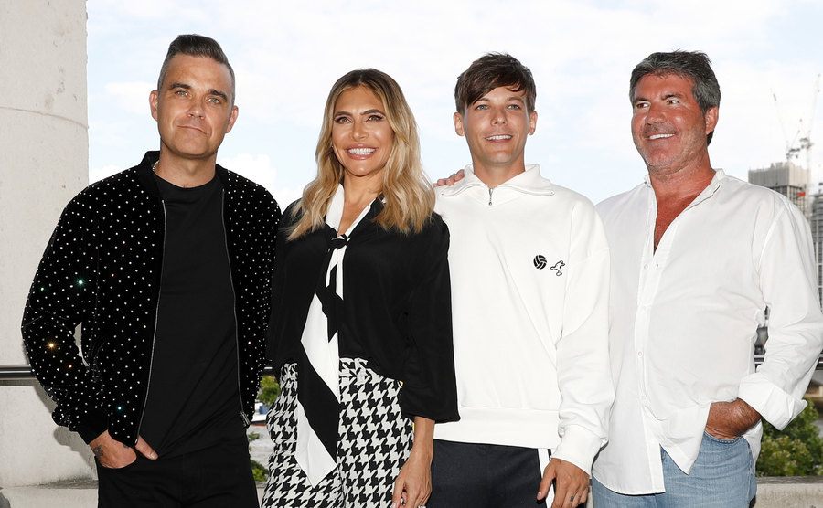 Robbie Williams, Ayda Field, Louis Tomlinson, and Simon Cowell pose during a launching event.