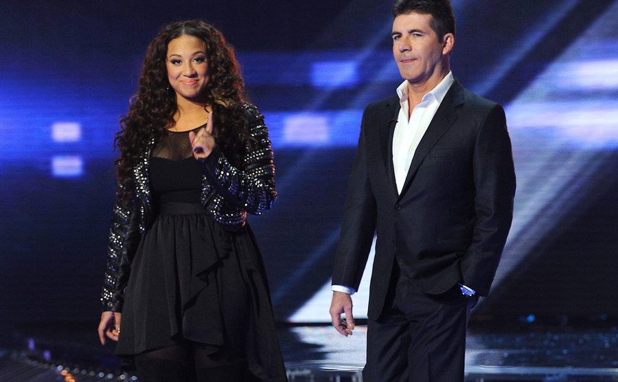 A picture of Melanie Amaro and Simon Cowell onstage.