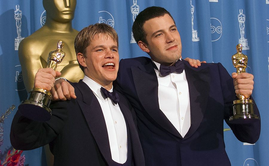 Ben Affleck and Matt Damon hold their Oscar Awards backstage. 