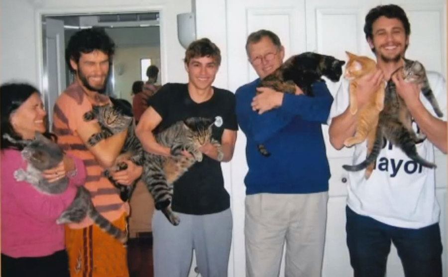 The Franco family poses with their cats.