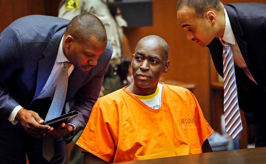 A photo of Michael sitting in court next to his attorney.