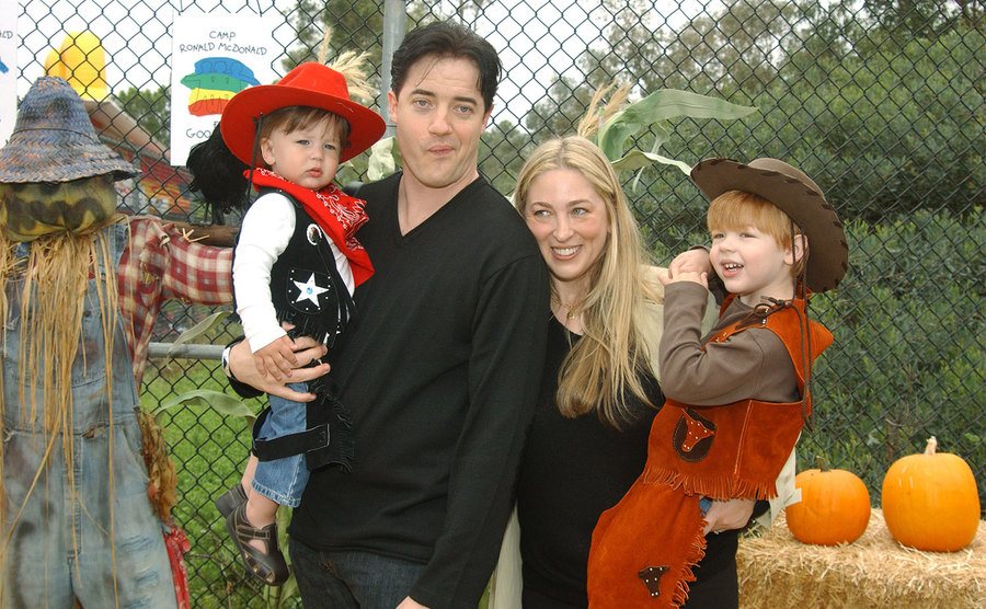 Brendan Fraser, wife Afton, and sons Holden and Griffin pose in a pumpkin patch.
