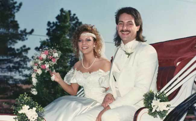 Martina and John McBride ride in a horse drawn carriage on their wedding day.