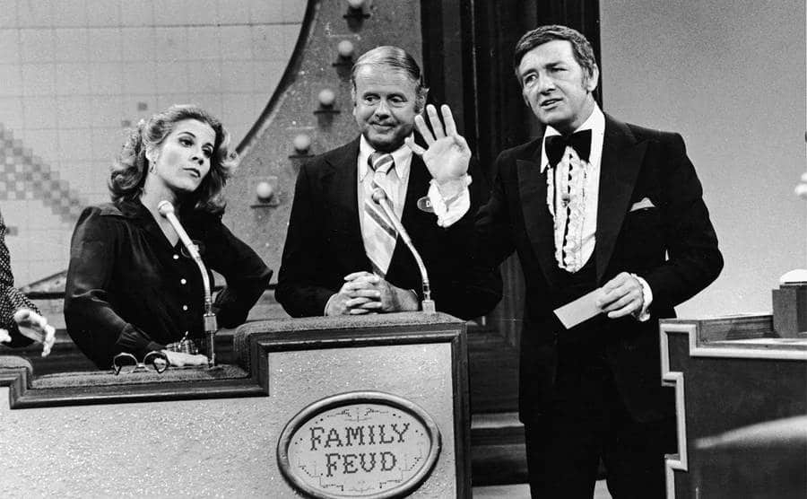 Richard Dawson speaks to the cast of ‘Eight Is Enough' as they compete on the game show, 'Family Feud'.