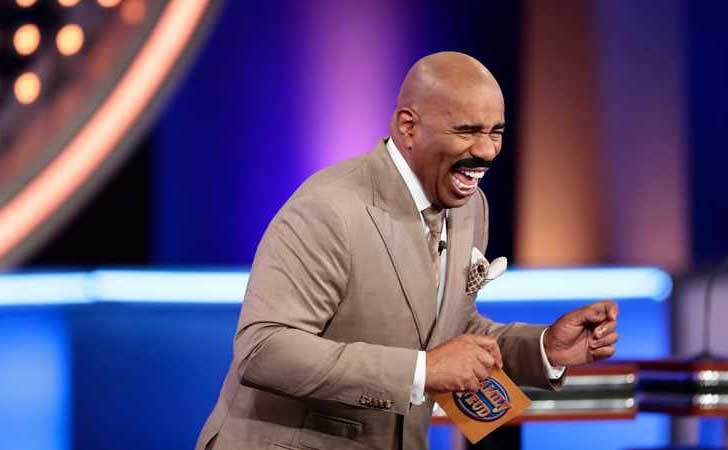 Harvey breaks into laugher on the set of Family Feud.