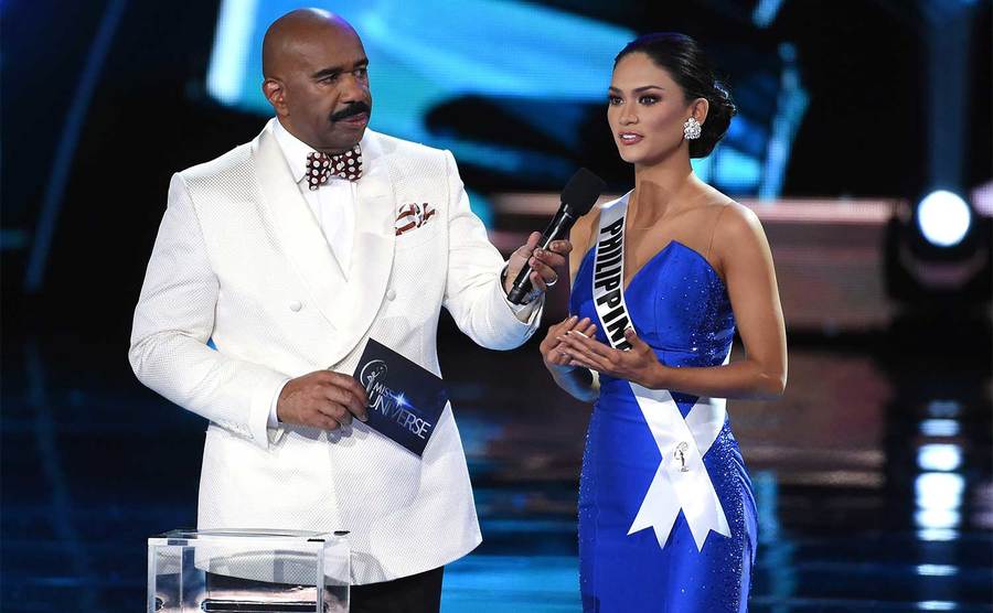 Steve Harvey listens as Miss Philippines 2015, Pia Alonzo Wurtzbach, answers a question.