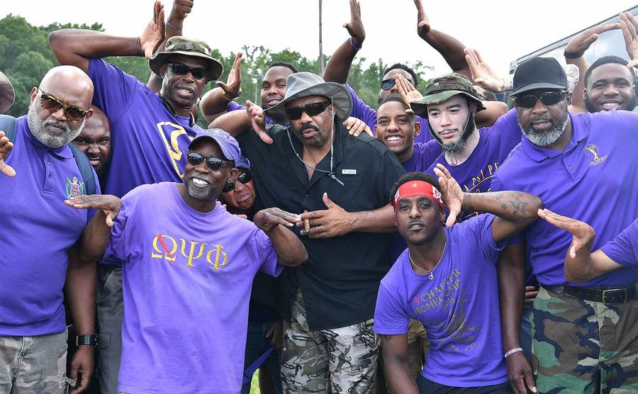 Steve Harvey poses with members of Omega Psi Phi Fraternity at a charity event.