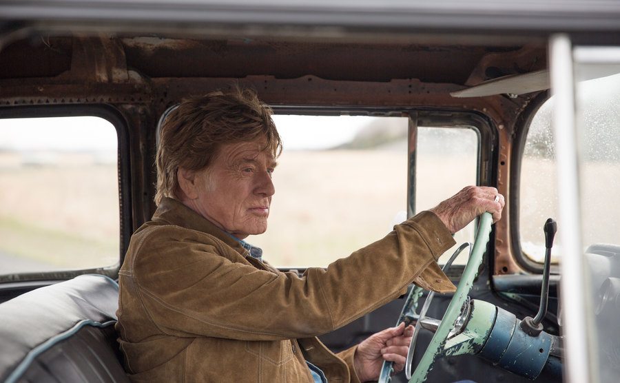 A still of Robert Redford as Forrest Tucker driving a car.