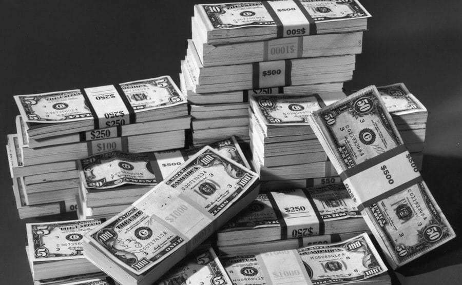 An image of organized piles of dollar bills.