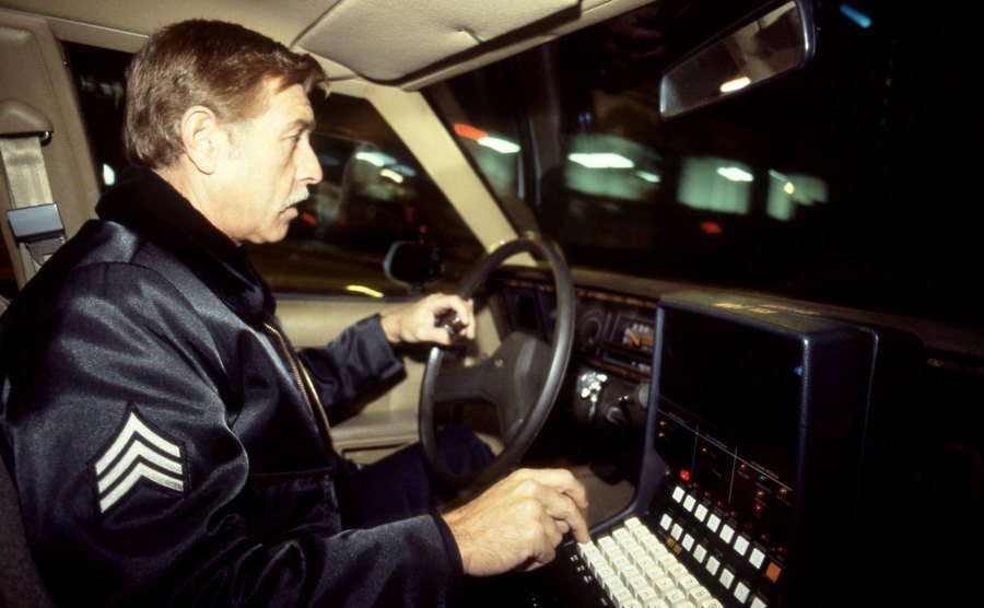 A police officer drives a patrol car.
