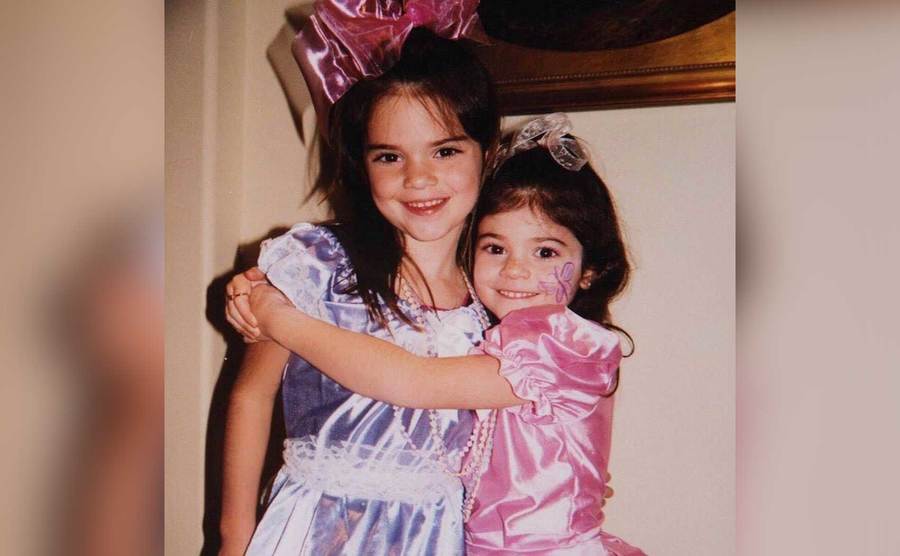 Kendall and Kylie are hugging as young girls.