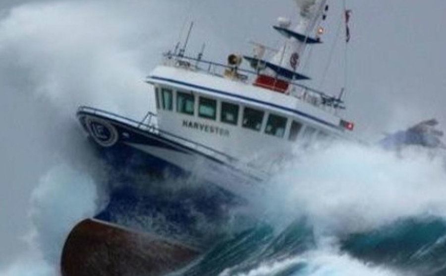 A picture of a boat in the middle of a sea storm.