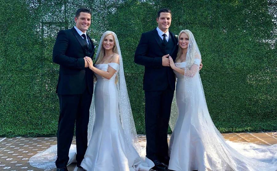 Brittany and Briana Dean on their wedding day with their husbands.