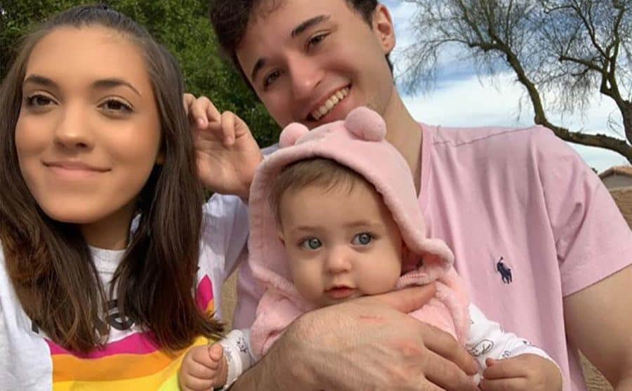 Chloe Mendoza and Max Schenzel take a picture with their baby girl.