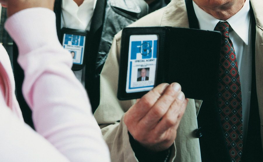 An image of FBI officers approaching a woman.