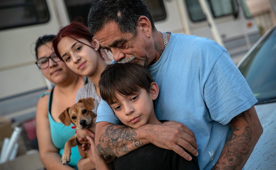A family embraces outside their RV. 