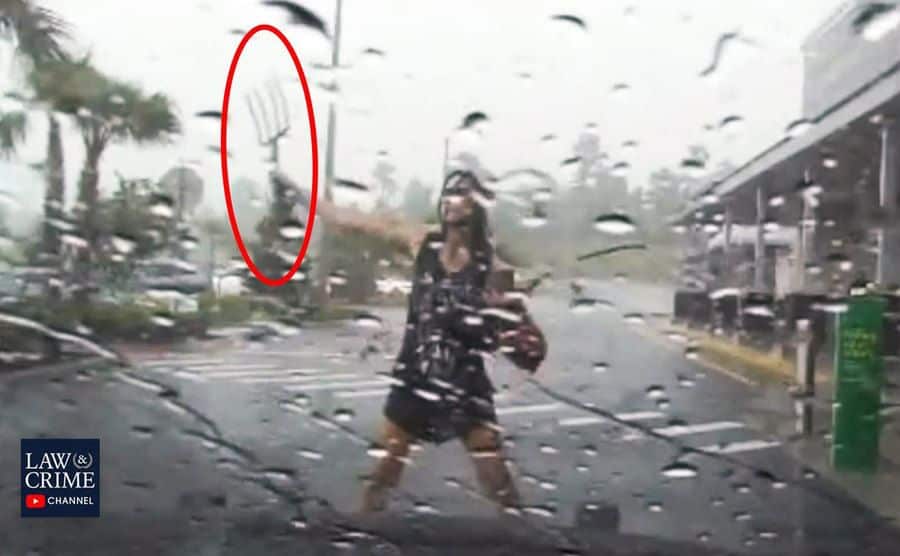Dashboard footage of the woman holding a pitchfork in the street.