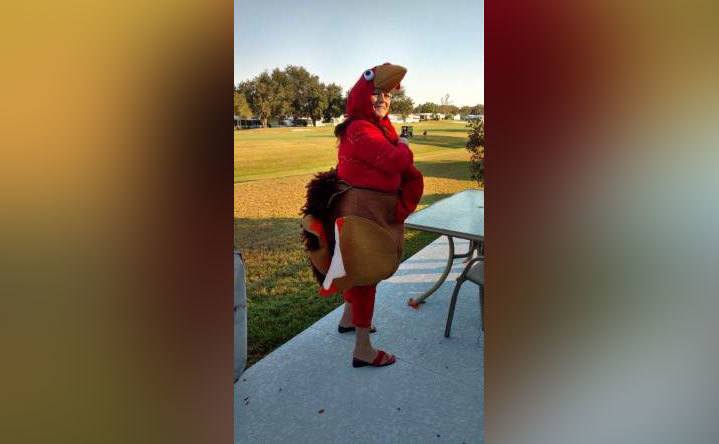 A woman poses in a turkey costume.