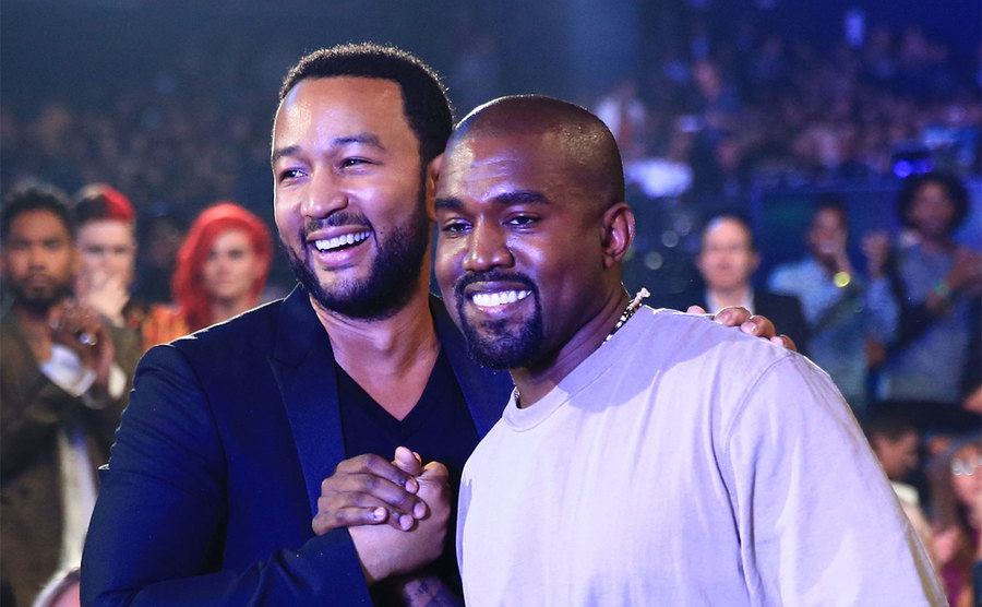 Kanye and John Legend attend an event.