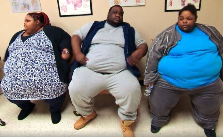 Three obese people sit in a waiting room.