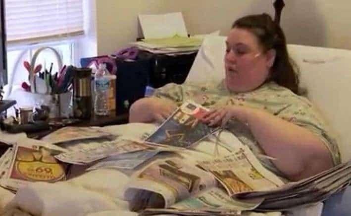 A large woman sits in a hospital bed.