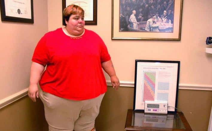 An obese woman is being weighed.