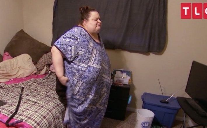 An obese woman is at home.