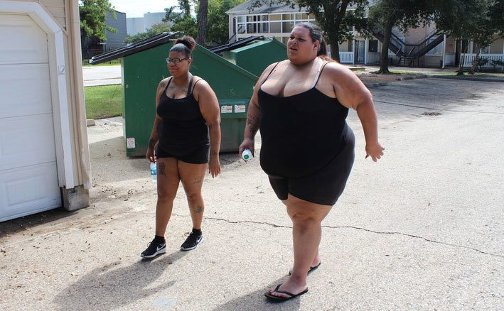 Two overweight woman are out for a walk.
