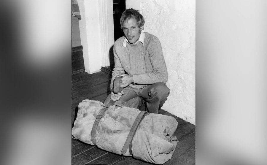 Ansell sits on the floor while packing his belongings.