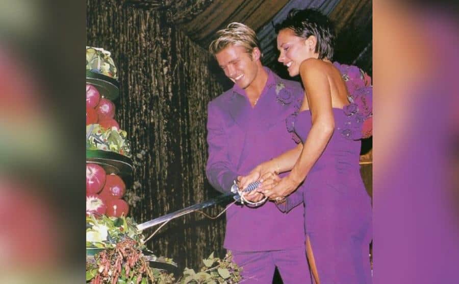 David and Victoria cut into their wedding cake.