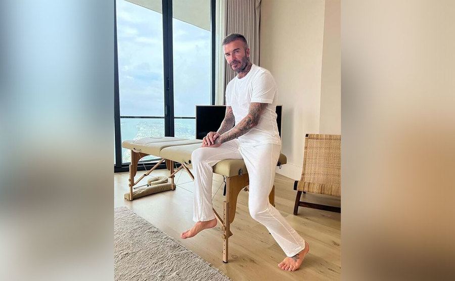 David Beckham sits on a massage table.