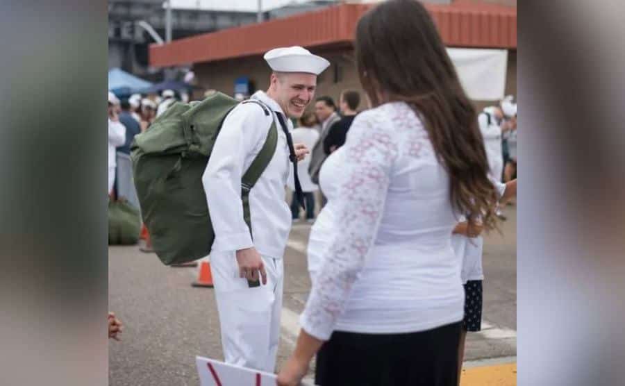 Chris smiles at his pregnant wife.