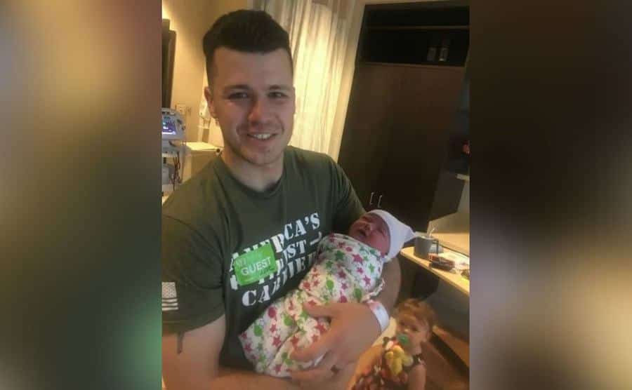 Chris holds his new baby girl.