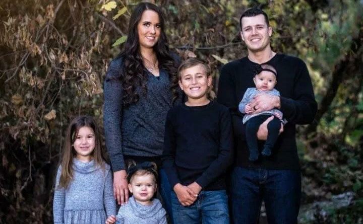 Chris and Natasha pose with their four kids.