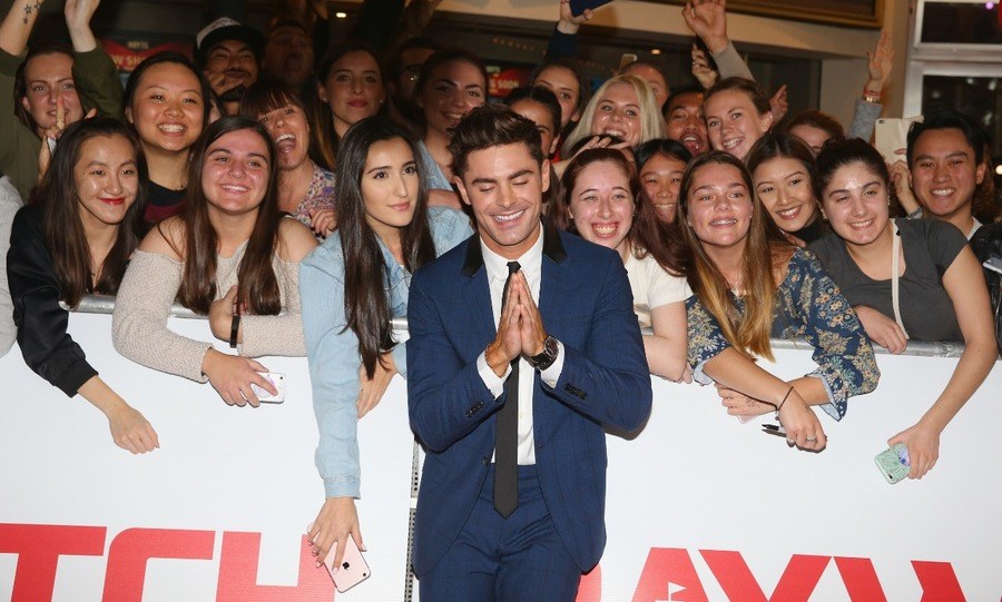 Zac Efron poses alongside fans